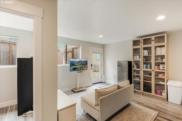 living area with wood finished floors, baseboards, and recessed lighting