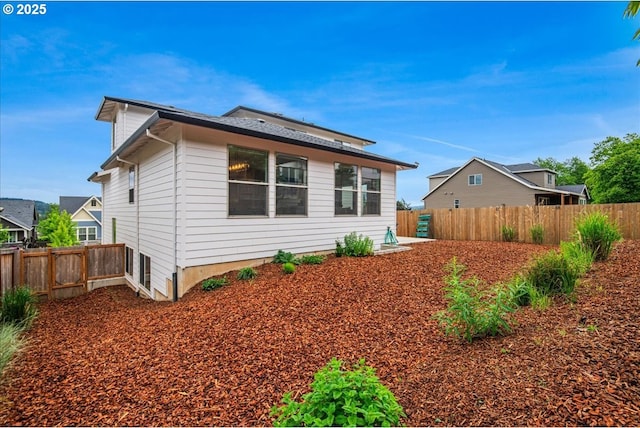 rear view of property with a fenced backyard