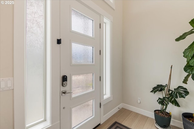 foyer entrance with light wood finished floors and baseboards