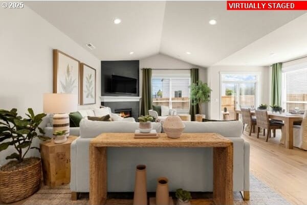 10494 SE Reverent Rd Unit 315, Happy Valley, OR 97086 - living room featuring recessed lighting, vaulted ceiling, a warm lit fireplace, and wood finished floors