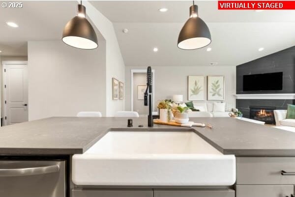 10494 SE Reverent Rd Unit 315, Happy Valley, OR 97086 - kitchen featuring stainless steel dishwasher, a glass covered fireplace, open floor plan, recessed lighting, and a sink