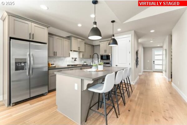 10494 SE Reverent Rd Unit 315, Happy Valley, OR 97086 - kitchen featuring built in appliances, a breakfast bar area, recessed lighting, tasteful backsplash, and gray cabinetry