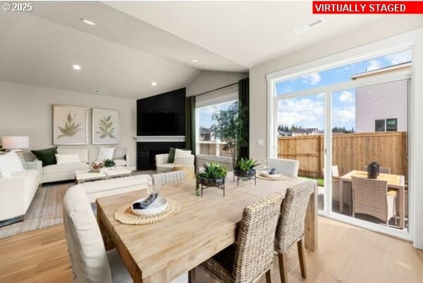 10494 SE Reverent Rd Unit 315, Happy Valley, OR 97086 - dining area featuring a fireplace, recessed lighting, light wood-style flooring, and lofted ceiling
