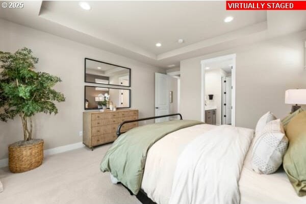 10494 SE Reverent Rd Unit 315, Happy Valley, OR 97086 - bedroom featuring light colored carpet, baseboards, connected bathroom, a tray ceiling, and recessed lighting
