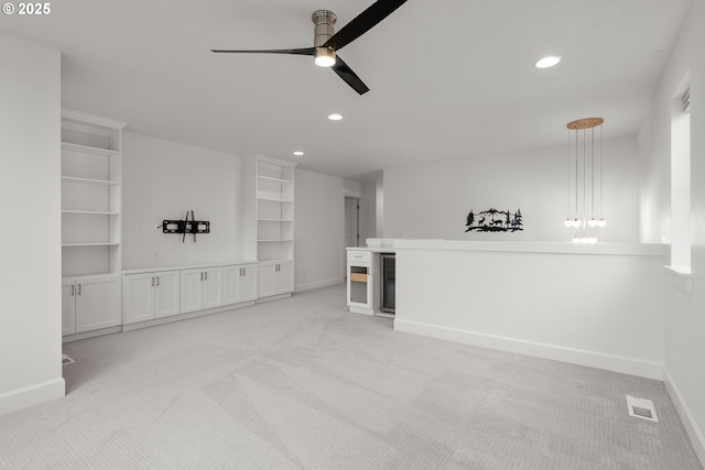 unfurnished living room featuring ceiling fan and light colored carpet