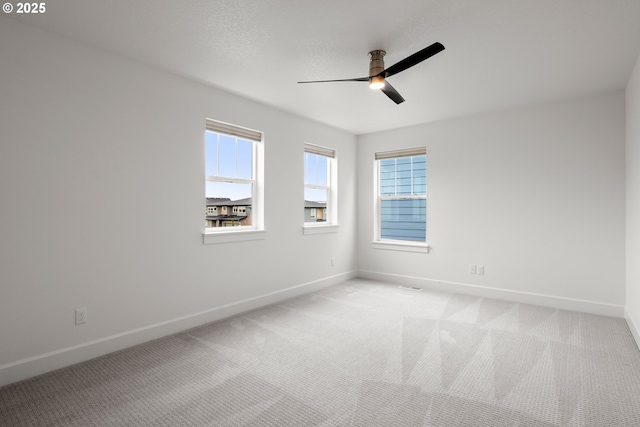 empty room with ceiling fan and light colored carpet