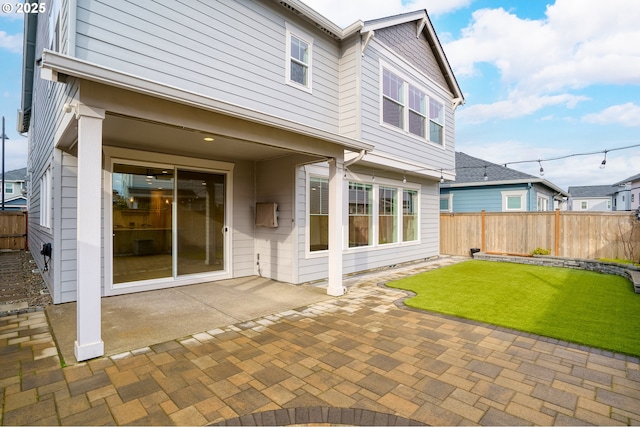 rear view of house featuring a patio area and a yard