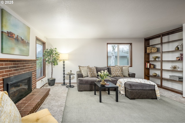 living area with carpet floors, a brick fireplace, and a textured ceiling