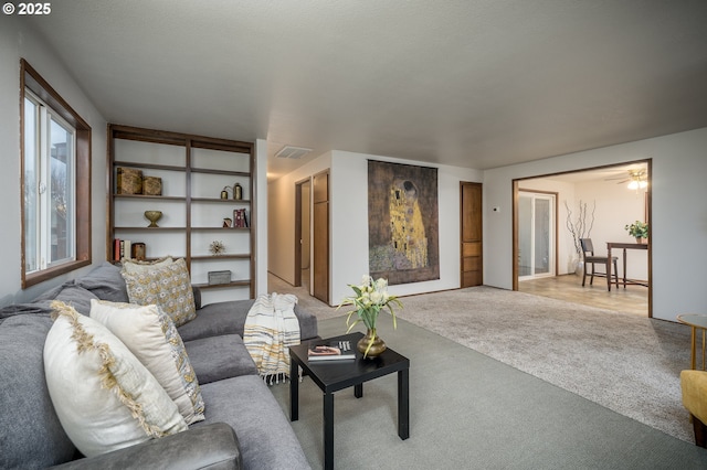 living room with visible vents and light colored carpet