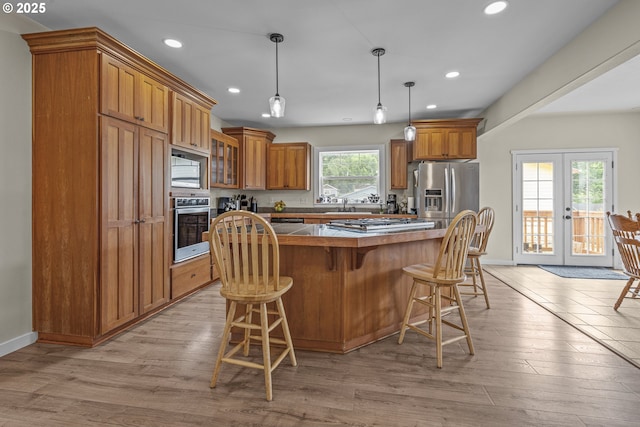 245 NE Balm St, Sheridan, OR 97378 - kitchen with stainless steel appliances, french doors, brown cabinetry, recessed lighting, and a kitchen breakfast bar