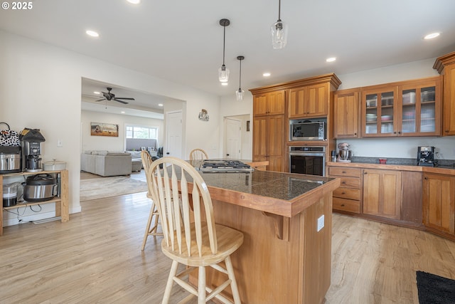 245 NE Balm St, Sheridan, OR 97378 - kitchen featuring appliances with stainless steel finishes, tile countertops, brown cabinetry, light wood finished floors, and recessed lighting