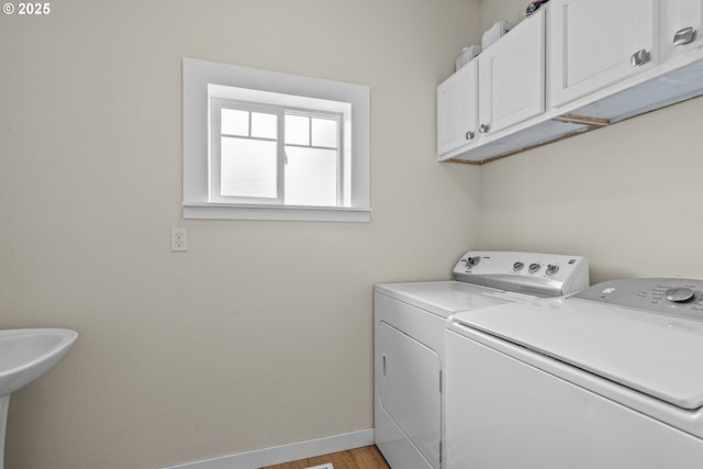 245 NE Balm St, Sheridan, OR 97378 - laundry area with washer and clothes dryer, cabinet space, baseboards, and light wood-type flooring
