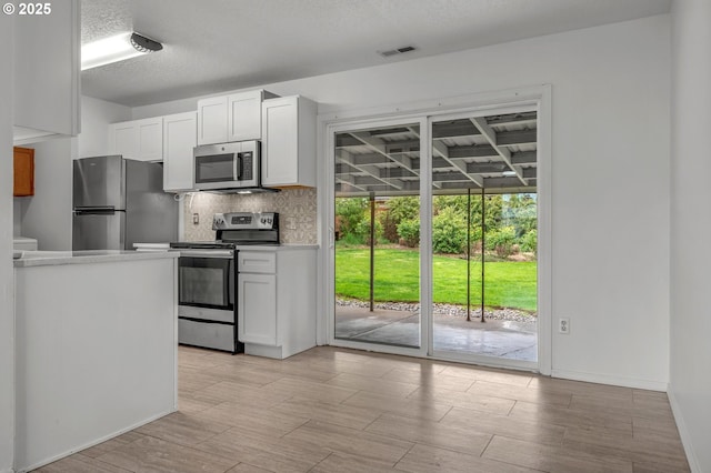 kitchen with light countertops, white cabinetry, appliances with stainless steel finishes, and tasteful backsplash