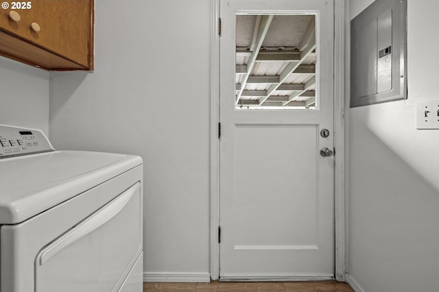 laundry room featuring baseboards, cabinet space, washer / clothes dryer, and electric panel