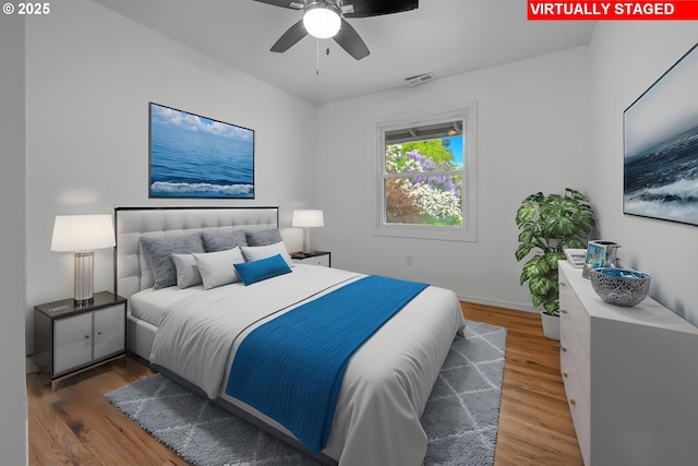 bedroom featuring a ceiling fan, baseboards, visible vents, and wood finished floors