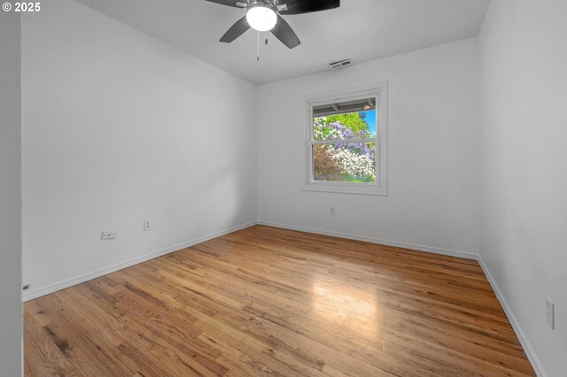 spare room featuring visible vents, baseboards, ceiling fan, and light wood-type flooring