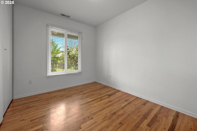 spare room featuring visible vents, baseboards, and light wood-type flooring