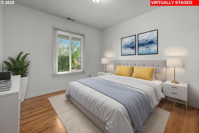 bedroom featuring baseboards, visible vents, and light wood-type flooring