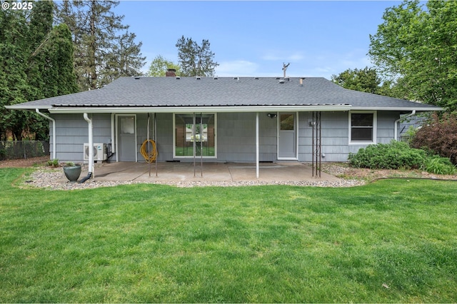 rear view of house with a lawn, a patio, a chimney, and roof with shingles