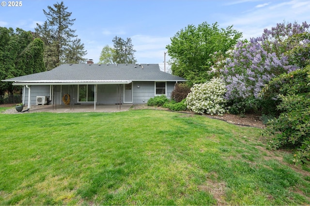 back of property with a lawn, ac unit, and a patio area