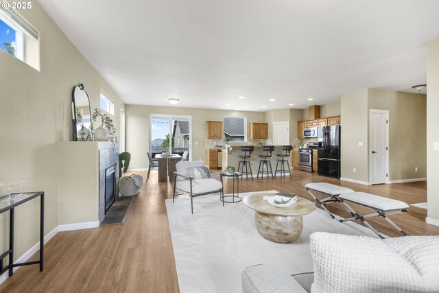 3678 Snowberry Rd, Eugene, OR 97403 - living room with baseboards, light wood finished floors, a tile fireplace, and recessed lighting