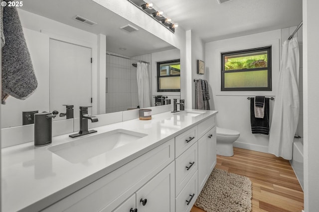 19919 SE Borges Rd, Damascus, OR 97089 - full bath featuring double vanity, toilet, wood finished floors, shower / bath combination with curtain, and baseboards