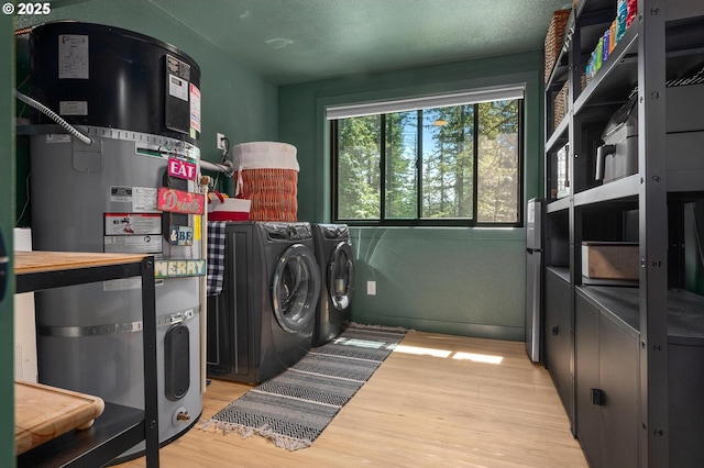19919 SE Borges Rd, Damascus, OR 97089 - laundry room featuring washer and clothes dryer, light wood-style flooring, and secured water heater