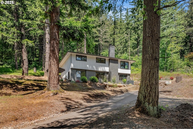 19919 SE Borges Rd, Damascus, OR 97089 - view of front facade with a chimney, brick siding, and a forest view