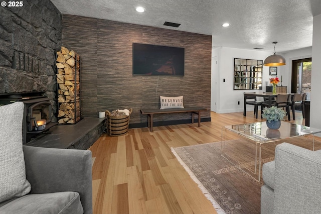 19919 SE Borges Rd, Damascus, OR 97089 - living room with baseboards, a textured ceiling, wood finished floors, and a wood stove