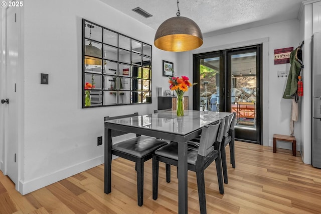 19919 SE Borges Rd, Damascus, OR 97089 - dining space featuring light wood-style floors, baseboards, and a textured ceiling