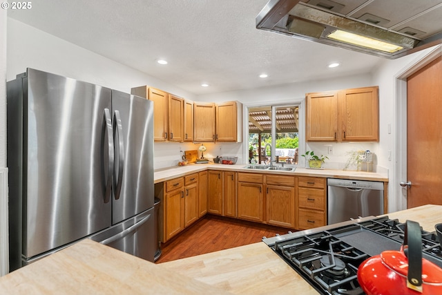 16511 NE Wasco St, Portland, OR 97230 - kitchen with appliances with stainless steel finishes, light countertops, wood finished floors, recessed lighting, and range hood