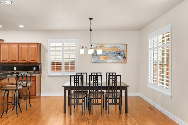 dining area featuring baseboards, recessed lighting, and light wood finished floors