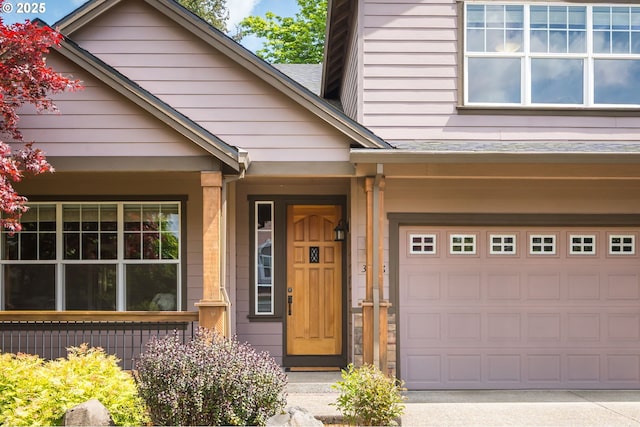 property entrance with a garage and driveway