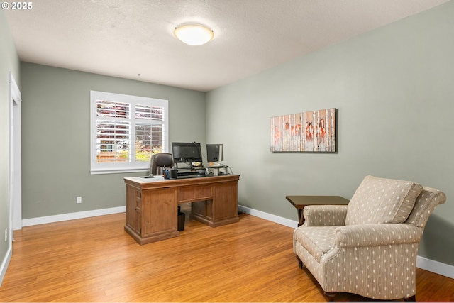 office space featuring baseboards and light wood-style floors