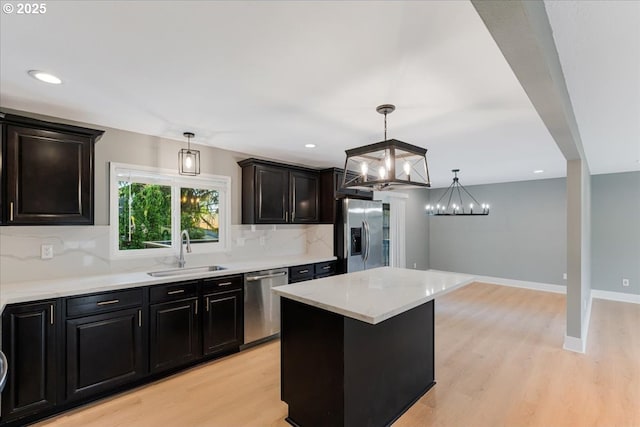 2706 SE Spruce St, Hillsboro, OR 97123 - kitchen with stainless steel appliances, a sink, light wood-style floors, backsplash, and a chandelier