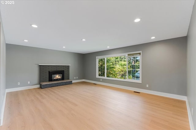 2706 SE Spruce St, Hillsboro, OR 97123 - unfurnished living room with light wood-style floors, baseboards, recessed lighting, and a brick fireplace