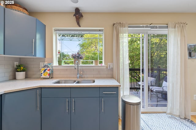6708 N Pittsburg Ave, Portland, OR 97203 - kitchen featuring a sink, blue cabinetry, backsplash, and light stone counters