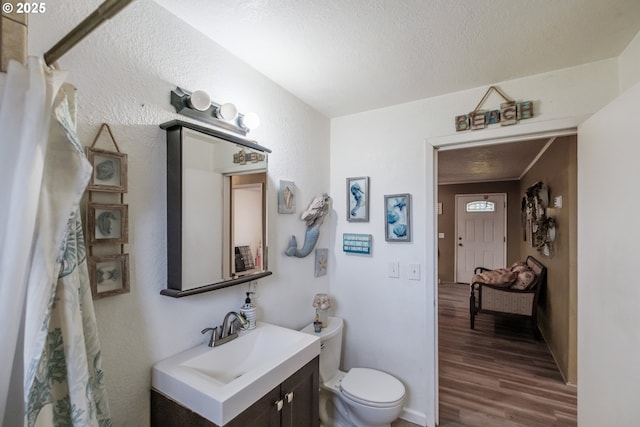 31501 Stoltz Hill Rd, Lebanon, OR 97355 - full bathroom with toilet, wood finished floors, vanity, a textured wall, and a textured ceiling