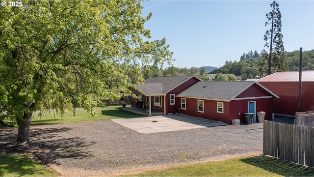 31501 Stoltz Hill Rd, Lebanon, OR 97355 - back of house featuring a patio, gravel driveway, and a shingled roof