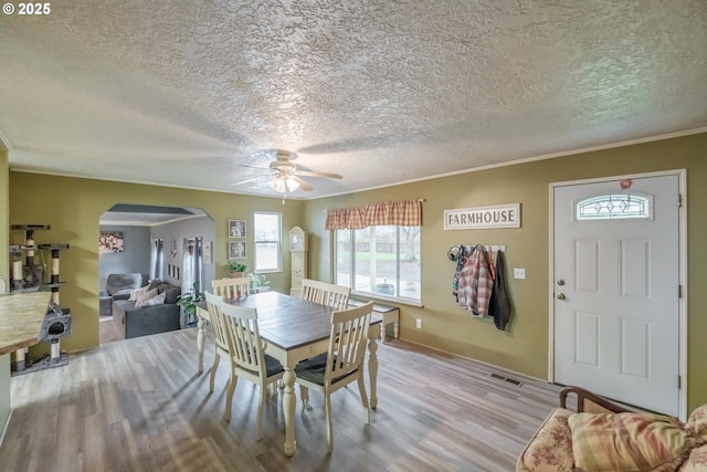 31501 Stoltz Hill Rd, Lebanon, OR 97355 - dining space featuring arched walkways, wood finished floors, a ceiling fan, a textured ceiling, and ornamental molding