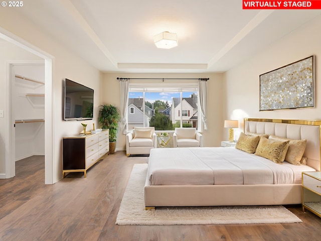 42019 NW Oak Way, Banks, OR 97106 - bedroom with a tray ceiling, a spacious closet, and wood finished floors