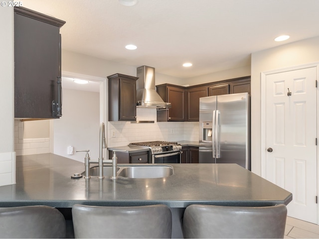 42019 NW Oak Way, Banks, OR 97106 - kitchen featuring appliances with stainless steel finishes, wall chimney exhaust hood, dark countertops, dark brown cabinets, and a peninsula