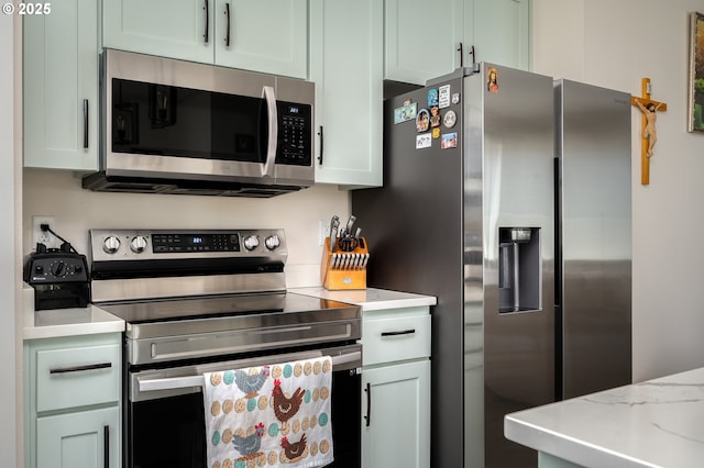 kitchen with light stone countertops and appliances with stainless steel finishes