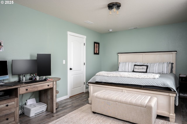 bedroom featuring visible vents, wood finished floors, and baseboards