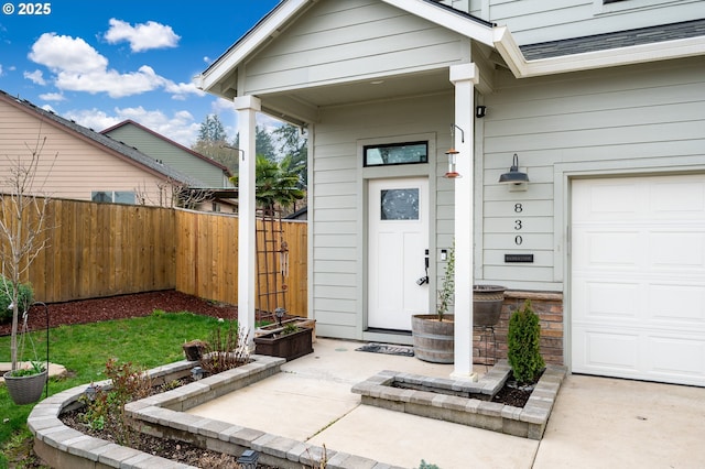 entrance to property with a shingled roof and fence