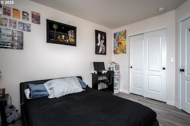 bedroom with a closet, baseboards, and wood finished floors