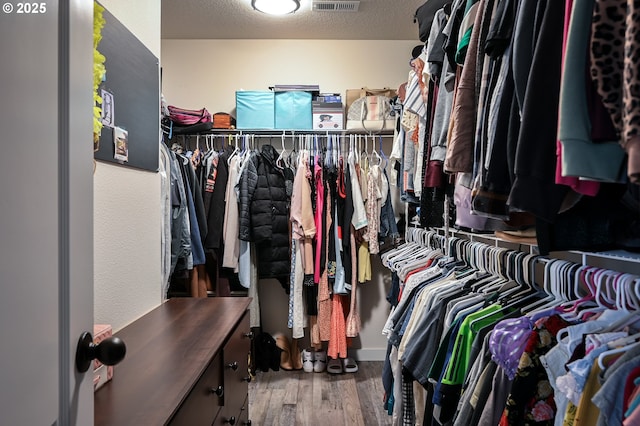 walk in closet featuring wood finished floors and visible vents