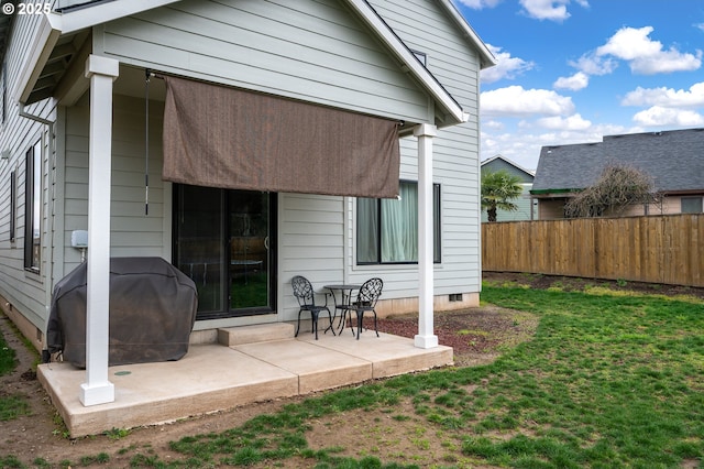 rear view of property with crawl space, a patio area, a lawn, and fence