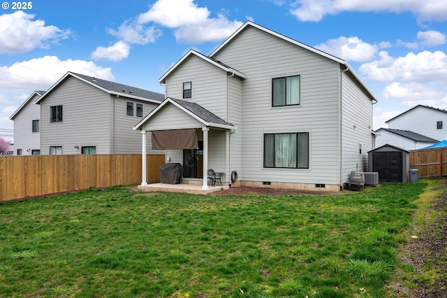 rear view of property with a yard, a fenced backyard, an outdoor structure, a storage unit, and a patio