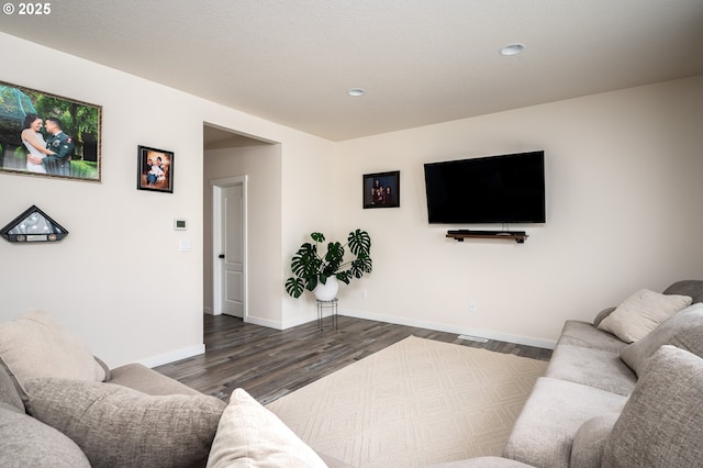 living area with baseboards and wood finished floors